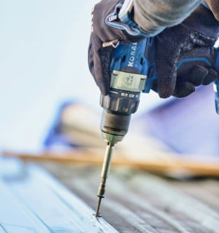 a-person-using-a-drill-to-drill-a-piece-of-wood.jpg a person using a drill to drill a piece of wood